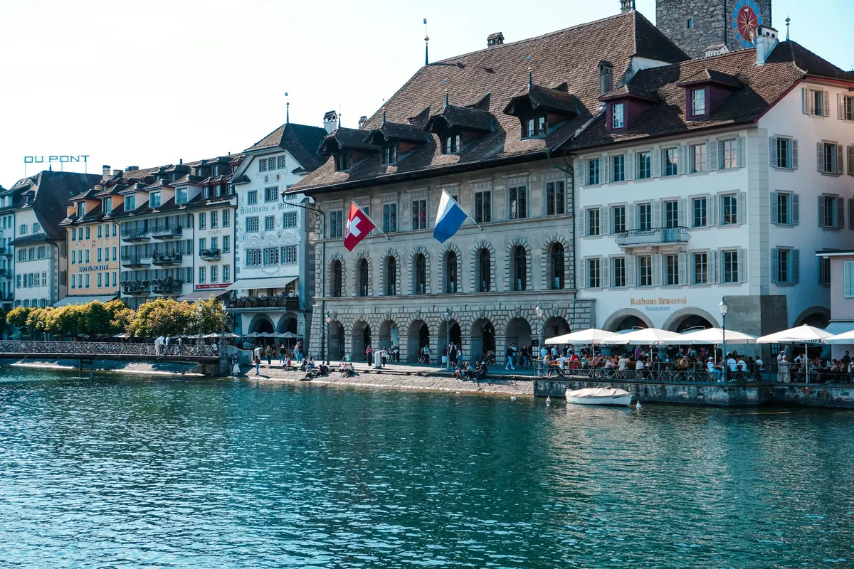 Historische Häuserzeile mit Fahnen am Reussufer in Luzern