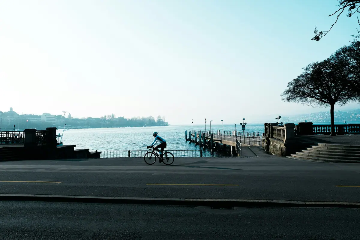 Velofahrer an der Seepromenade beim Bürkliplatz in Zürich im Morgenlicht
